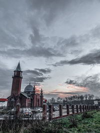 Buildings in city against cloudy sky