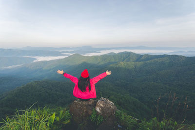 Man with arms raised against mountains