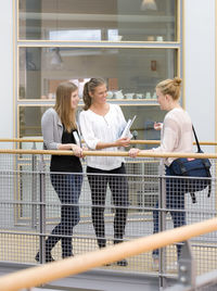 Three university student talking at corridor