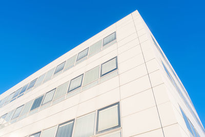 Low angle view of modern building against clear blue sky