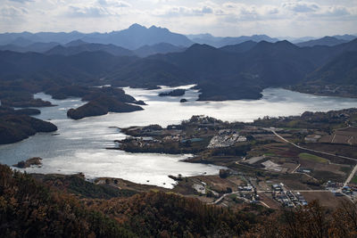 High angle view of lake and mountains against sky