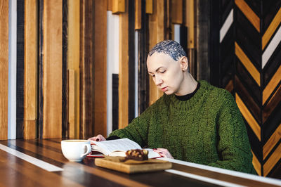 Young woman with coffee cup on table