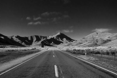 Country road and mountains against sky