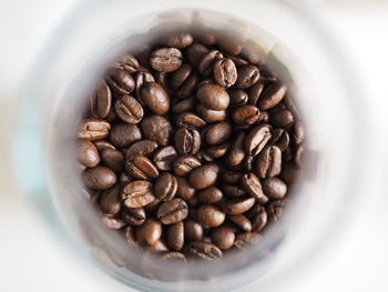 Directly above shot of roasted coffee beans in jar on table