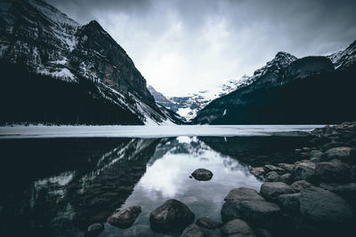 Scenic view of lake by mountain against sky