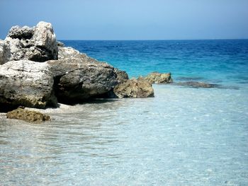 Scenic view of sea with rocks in background