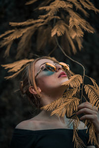 Portrait of woman holding sunglasses