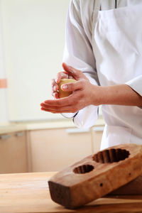 Close-up of hand holding food on cutting board