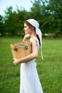 Young woman using mobile phone while standing on field