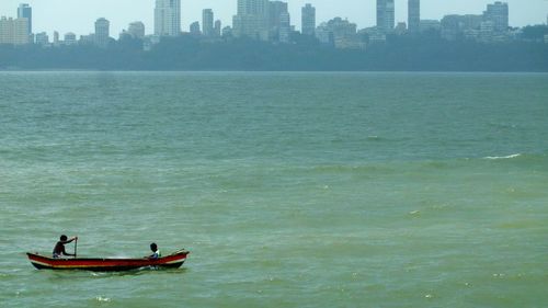 Men sailing boat over sea