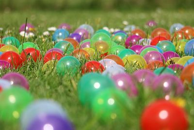 Close-up of colorful balls on grassy field at park during sunny day