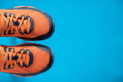 Low section of shoes against blue background