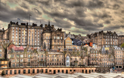 Buildings in city against cloudy sky