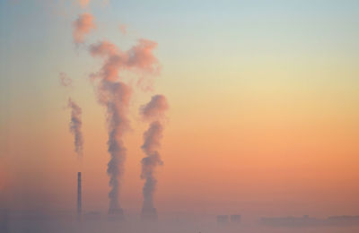 Pipe factory smoke obscured by fog background pink sky