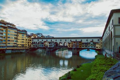 Bridge over river in city against sky