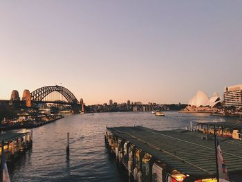 Bridge over river in city against clear sky