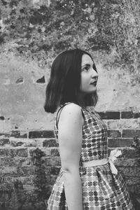 Portrait of woman standing against wall