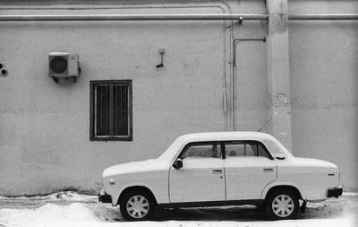 Old car on building in city during winter