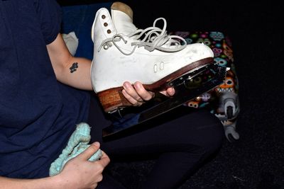 Midsection of woman holding ice skate