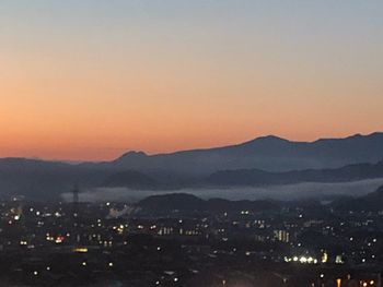 Scenic view of silhouette mountains against romantic sky at sunset