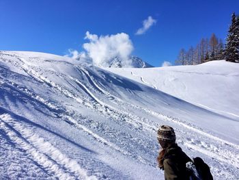 Woman on snowcapped mountain against sky