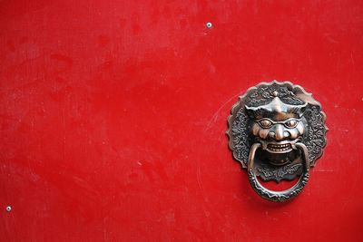 Full frame shot of red wooden door with metallic knocker
