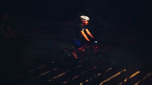 Reflection of man in illuminated mirror