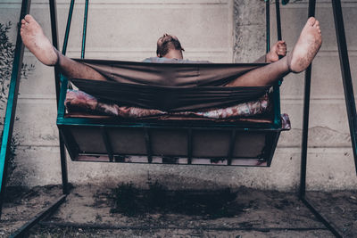 Low angle view of man swinging in yard