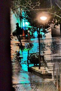 Reflection of people on wet street at night