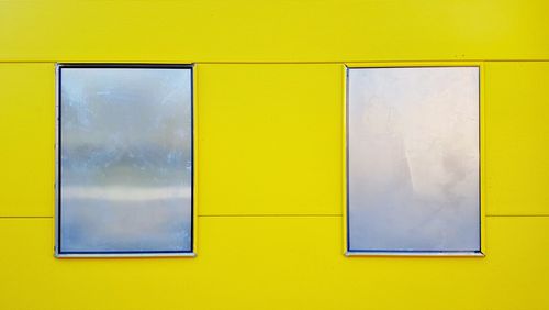 Detail shot of a yellow wall and tin windows