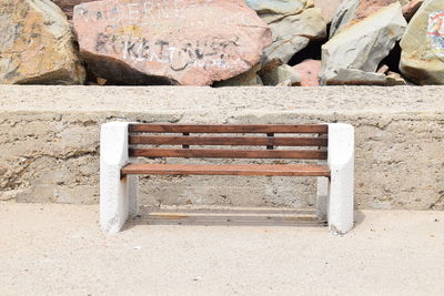 Close-up of empty bench on rock