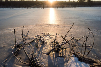 Scenic view of frozen lake against sky during sunset