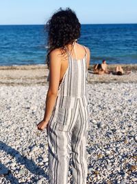 Rear view of woman standing on beach