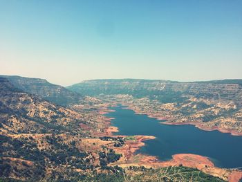 High angle view of sea and mountains against clear sky