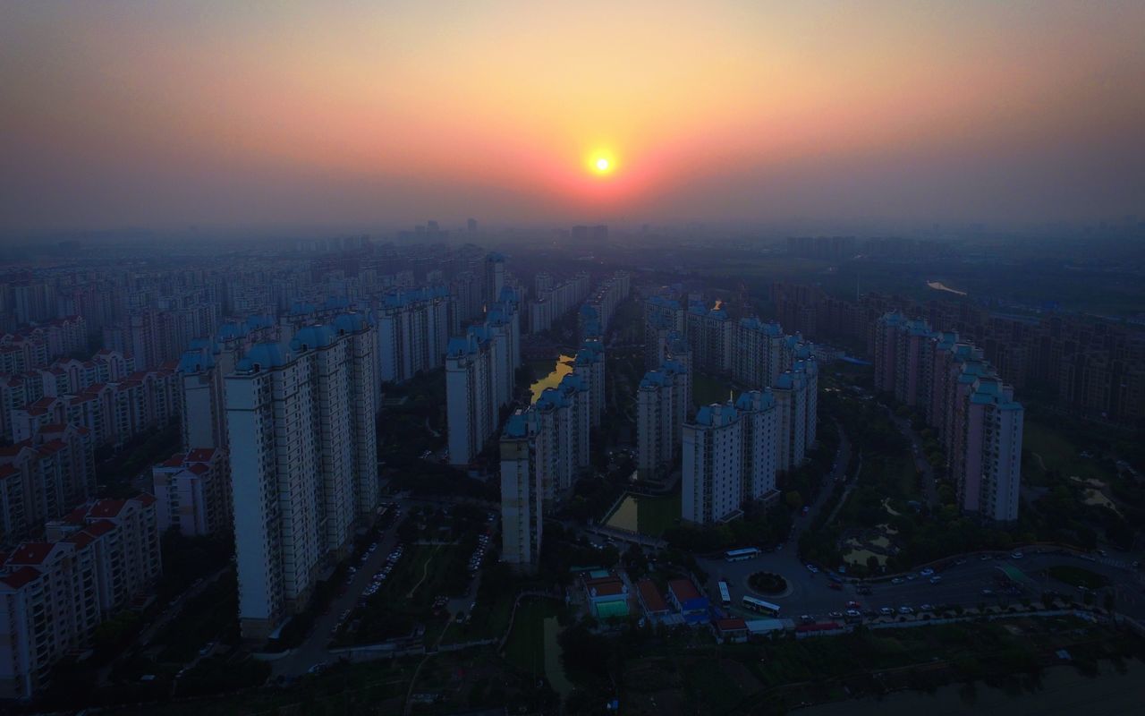 sunset, cityscape, city, building exterior, architecture, built structure, high angle view, orange color, crowded, sky, sun, residential district, skyscraper, aerial view, residential building, clear sky, residential structure, no people, outdoors, dusk