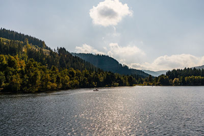 Scenic view of lake by mountain against sky