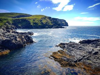 Rock formations by sea against sky