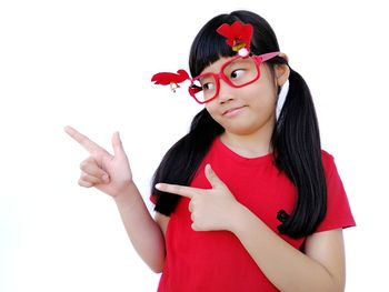 Portrait of beautiful young woman standing against white background