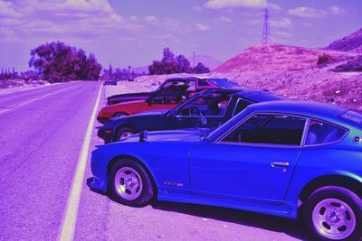 Cars on road against blue sky