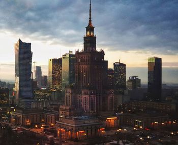 Buildings in city against cloudy sky