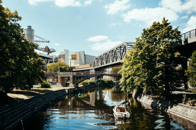 Bridge over canal amidst buildings in city against sky