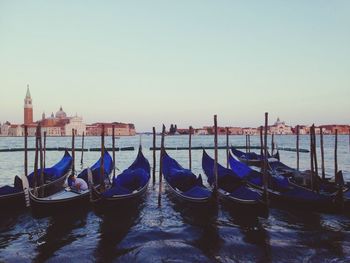 Boats moored in canal against clear sky