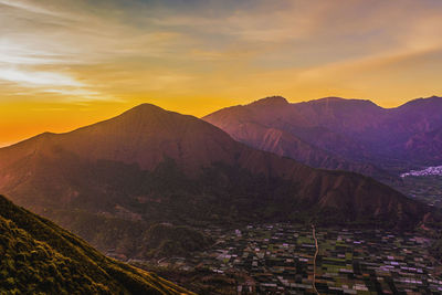 Scenic view of mountains against sky at sunset