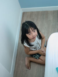 High angle portrait of asian girl sitting on floor at home