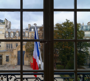 Buildings against sky seen through glass window