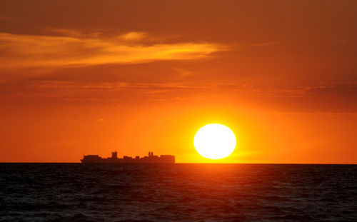 Scenic view of sea against orange sky