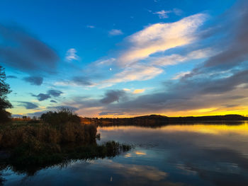 Scenic view of calm lake against cloudy sky