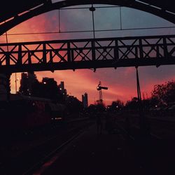 Railroad tracks in city against sky during sunset