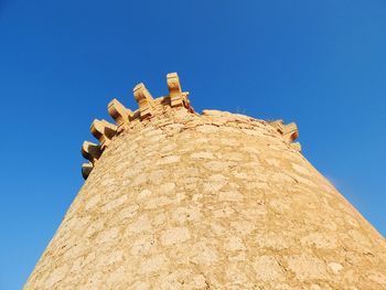 Low angle view of castle against clear blue sky