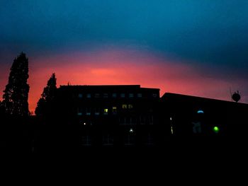 Silhouette buildings against sky at night